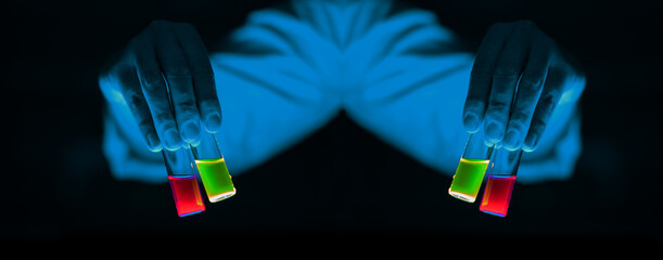 A woman scientist holding Organic chemistry sample glass vials in a laboratory - radioactive - fluorescence. A copy space black background.