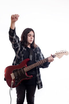 Vertical image of teenager raising his fist while playing electric guitar on white background.