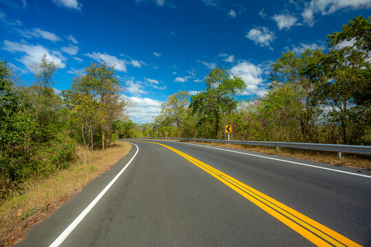 Long road with trees on roadside ,Empty asphalt road and natural landscape under the blue sky 