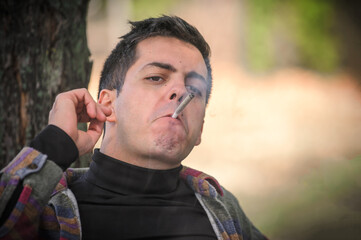 Closeup detail view of man smoke marijuana ganja joint cigarette