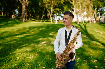 Young saxophonist plays melody on golden saxophone