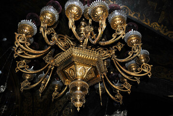 Stylized Medieval gilded chandelier with many candlesticks