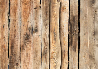 Old crooked wooden fence background with holes.