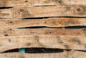 Old crooked wooden fence background with holes.