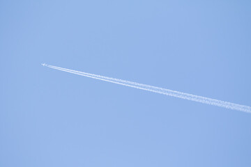 Blue sky and plane trail high in the sky.