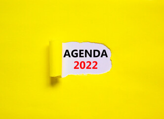 2022 agenda new year symbol. Words '2022 agenda' appearing behind torn yellow paper. Beautiful yellow background. Business, 2022 agenda new year concept, copy space.