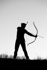 A silhouette of an archer firing an arrow
