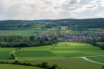 Fototapeta na wymiar View from an hill to the small village of Hochhausen with a church and the river Tauber in the Taubertal, Baden-Württemberg.
