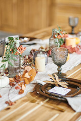 Long wooden table with kitchenware and decorations prepared for family and guests before festive dinner