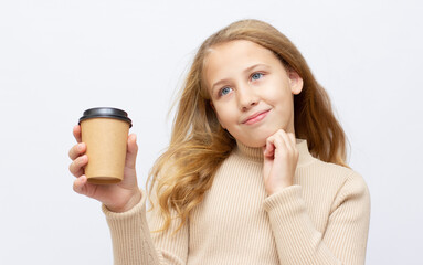 smiling teenager girl in brown sweater with disposable cup isolated on light grey