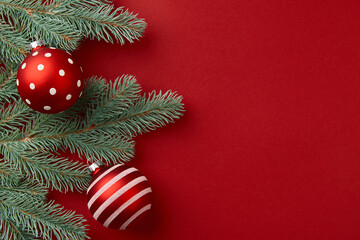 Christmas composition. Christmas tree branches and ornaments on red background