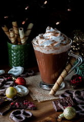 A cup of hot chocolate with whip cream and cocoa sprinkled on top.
