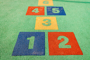 Numbers on the ground of a children's hopscotch in an artificial garden.