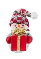 Smiling handmade snowman toy dressed in scarf and cap with red gift box with golded bow isolated on white background. symbol of Christmas and New year