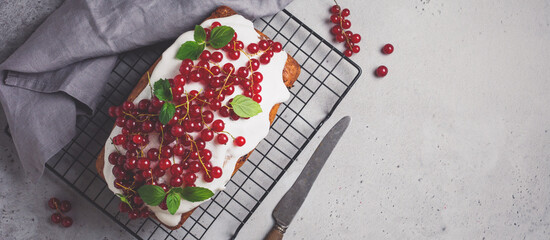 Bundt cake with glaze and red currant on gray concrete vintage background. Toned image. Top view