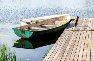 Fototapeta na wymiar Old plastic fishing boats on the bank of the lake