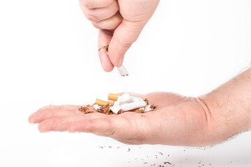 a human hand. the man on her hair. she breaks the cigarettes, and pours them into the other palm. on a white background. close-up