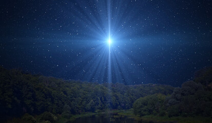 Star of Bethlehem, or Christmas Star over the night forest. A bright star indicates the Nativity of...