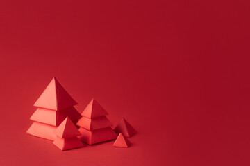 Five red Christmas trees made of paper on red background.