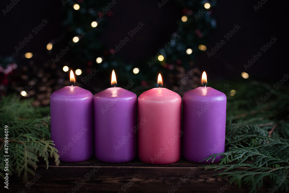 Wall mural a row of four burning purple advent candles christmas concept.