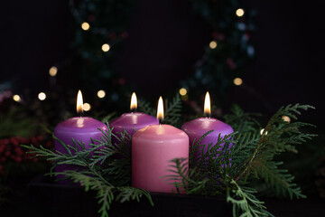 Obraz na płótnie Canvas Three purple and one pink advent candles in Christmas eve.