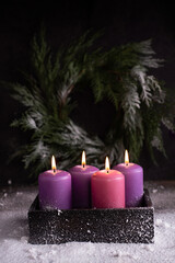 Obraz na płótnie Canvas Four Christmas burning pink and purple advent candles.