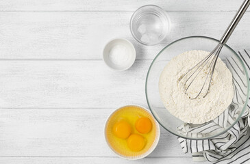 Ingredients for making raw pasta on a white wooden plate with copy space. Ingredients for baking on white background, top view, copy space