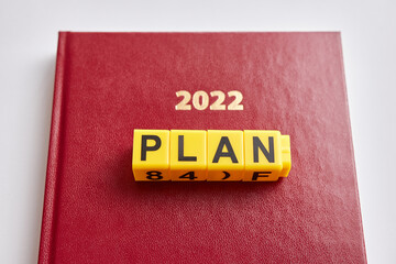 At the top of the 2022 business diary, the word plan consists of letters. Plans for 2022