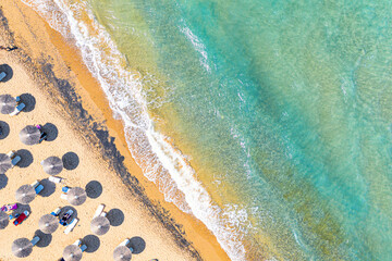 Top view aerial drone photo of Banana beach with beautiful turquoise water, sea waves and straw umbrellas. Vacation travel background. Ionian sea, Zakynthos Island, Greece