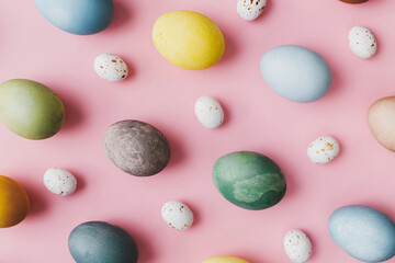 Stylish eggs flat lay on pink background. Modern natural dyed colorful easter eggs and and chocolate candy composition on pink. Greeting card, easter background