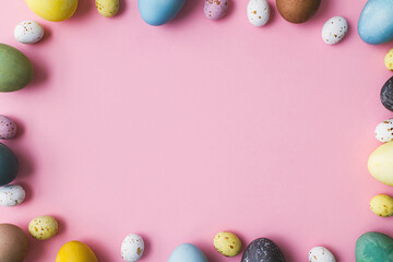 Stylish easter eggs frame flat lay on pink background. Modern natural dyed colorful easter eggs and...