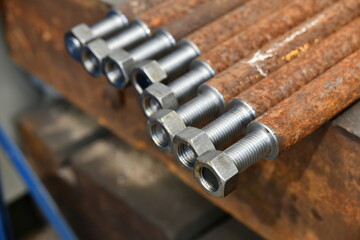 Studs with threaded threads and nuts after production on a cnc lathe.