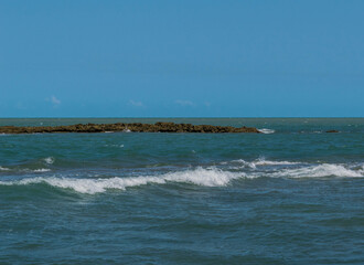 Linda vista de praia com muitas pedras e um c&eacute;u azul