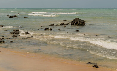 Linda vista de praia com muitas pedras e um céu azul