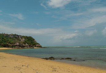 Fototapeta na wymiar Linda vista de praia com muitas pedras e um céu azul