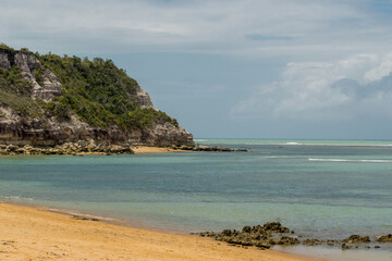 Linda vista de praia com mar, montanhas, mata e falêsias