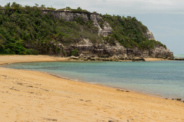 Linda vista de praia com mar, montanhas, mata e falêsias
