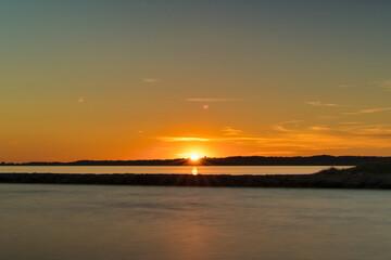 Fototapeta na wymiar Sunset with Sunrays cresting over the Horizon