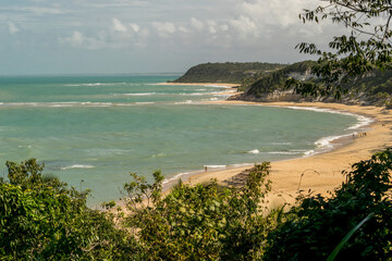Linda vista de cima de praia com mar, montanhas, mata e falêsias