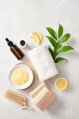 Organic yellow sea salt with lemon, massage oil, soap, towel  and a wooden brush on a white...