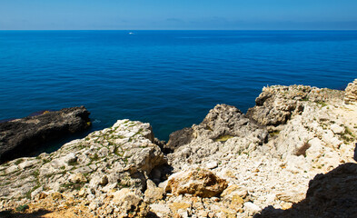 Fototapeta na wymiar Stones in a sea and blue sky, water background. Bay in Crimea. Black Sea