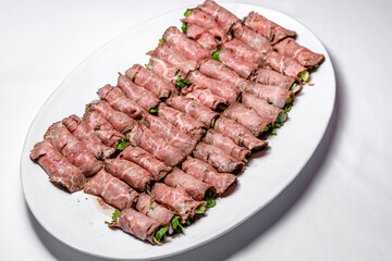 Slicing from pieces of meat stuffed with herbs. Selective focus.