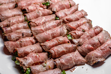 Slicing from pieces of meat stuffed with herbs. Selective focus.