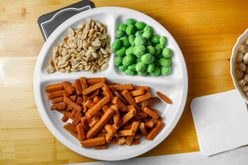 Delicious croutons, peanuts and wasabi nuts are on the plate. Appetizer for beer.