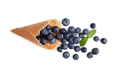 Wafer cone with tasty ripe bilberries on white background
