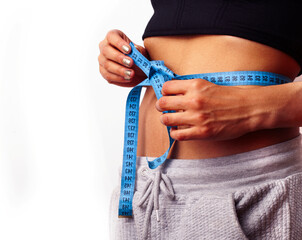 woman measuring waist with tape on knot, african tan isolated