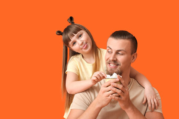 Happy daughter and father with cup of hot cocoa on color background