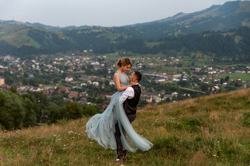 Beautifull wedding couple  embracing
on mountain with perfect viewd.