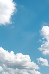 white clouds in a blue sky, in vertical format