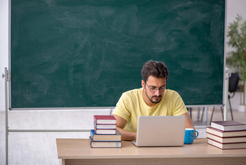 Young male student preparing for exams in the classroom